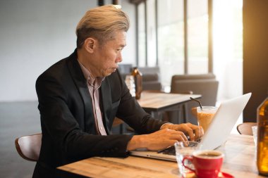 kafede dizüstü kullanarak Asya kıdemli erkek