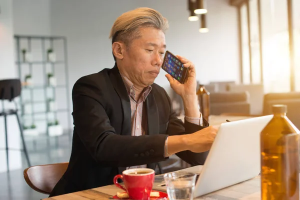 Ásia Sênior Masculino Usando Laptop Telefone Café — Fotografia de Stock