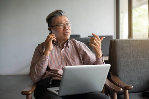 Asiatiska Senior Man Använder Laptop Och Telefon — Stockfoto