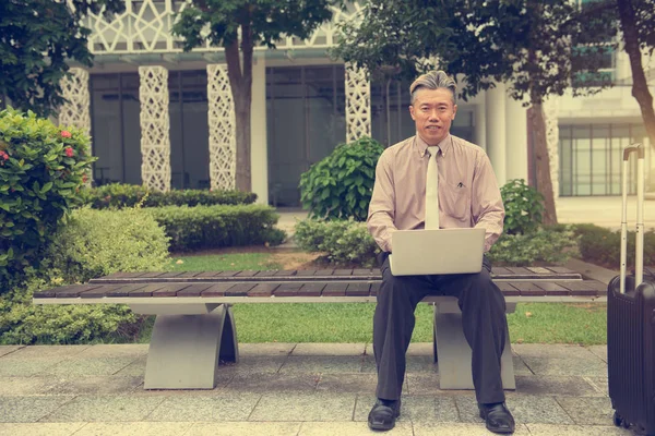 Aziatische Senior Man Met Laptop Buiten — Stockfoto