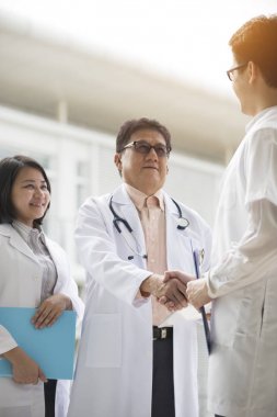 Asya sağlık ekibi el sıkışma modern klinik tarafından