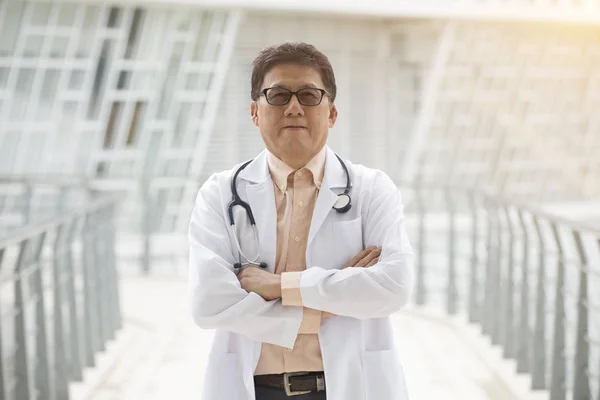 亚洲高级医生在现代诊所前 — 图库照片
