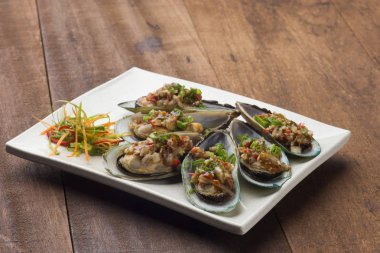 Midye beyaz tabakta sebze ile 