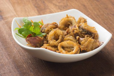 ahşap masa üzerinde beyaz tabak kızarmış kalamar 