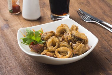 ahşap masa üzerinde beyaz tabak kızarmış kalamar 