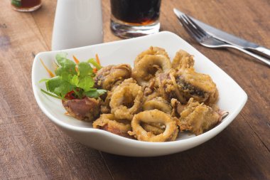 ahşap masa üzerinde beyaz tabak kızarmış kalamar 