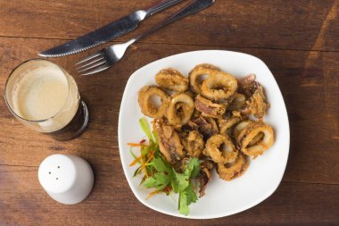 ahşap masa üzerinde beyaz tabak kızarmış kalamar 