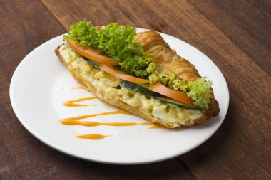 yumurtalı sandviç ve kahve beyaz plaka üzerinde 