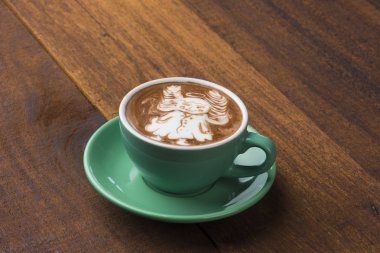 Tahta masada bir fincan sıcak latte sanat kahvesi.
