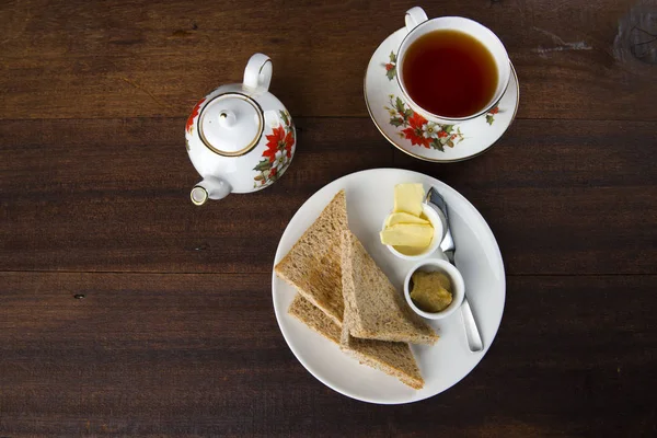 トースト バターと木製のテーブルのお茶 — ストック写真