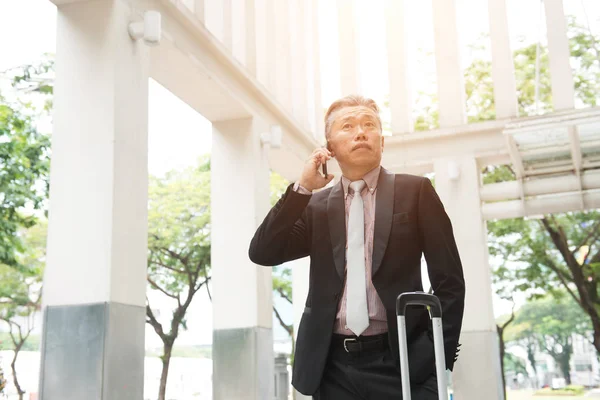 Lachende Senior Aziatische Zakenman Praten Smartphone Buurt Van Kantoorgebouw — Stockfoto