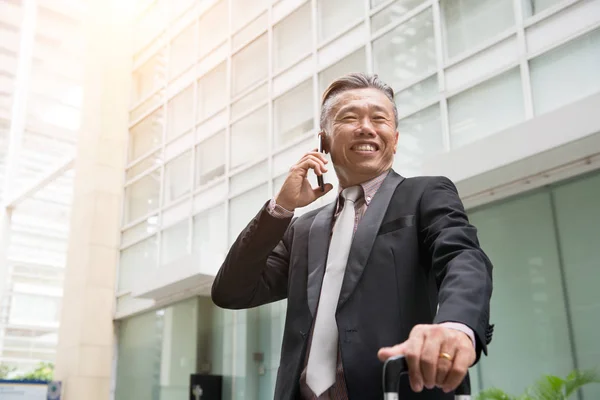 Lachende Senior Aziatische Zakenman Praten Smartphone Buurt Van Kantoorgebouw — Stockfoto