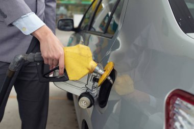Closeup of man pumping gasoline fuel in car at gas station clipart