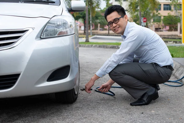 Young Asian Businessman Pumping Car Wheel — Stock Photo, Image