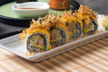 Gri arkaplanlı avokado suşisinin yakın plan çekimi.