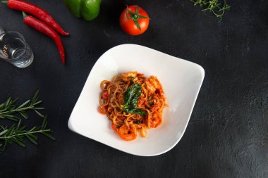 Karides, domates, fesleğen ve peynirli lezzetli spagetti.
