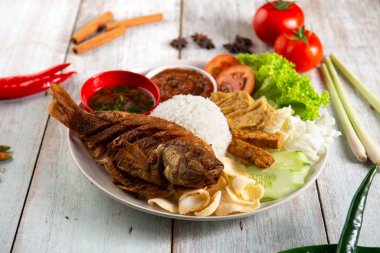 Geleneksel kızarmış balık, pilav, sambal, sebze ve karışık yemek.