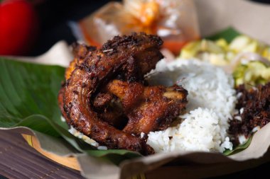 Geleneksel kızarmış tavuk pilavı, bitkiler, biberler ve salatalıklı acar.