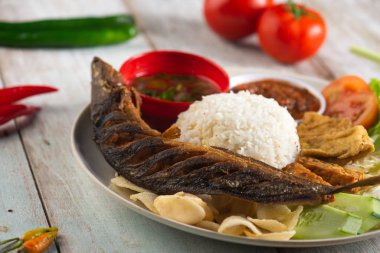 Kızarmış yayın balığı, pilav, sambal, sebze ve karışık yemek.