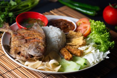 Geleneksel kızarmış pomfret balığı, pilav, sambal, sebze ve karışık yemek.