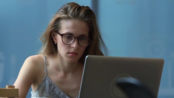 Hermosa mujer con gafas usando una computadora portátil — Vídeo de stock