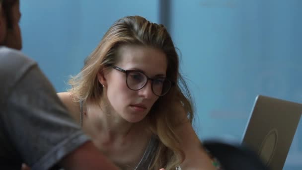 Красива жінка в окулярах за допомогою портативного комп'ютера — стокове відео