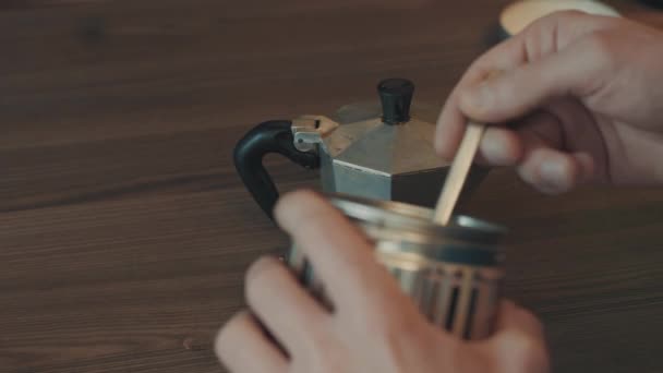 Omul care face cafea în gheizerul mașinii de cafea, o mână împușcă cafea preparată din sobă — Videoclip de stoc