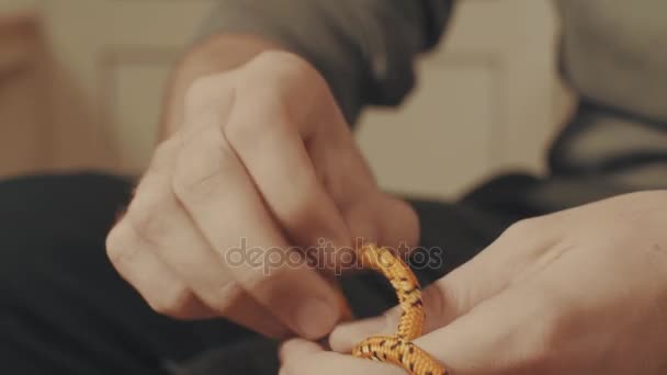 Mans hands tying a mountaineering knot on a rope — Stock Video