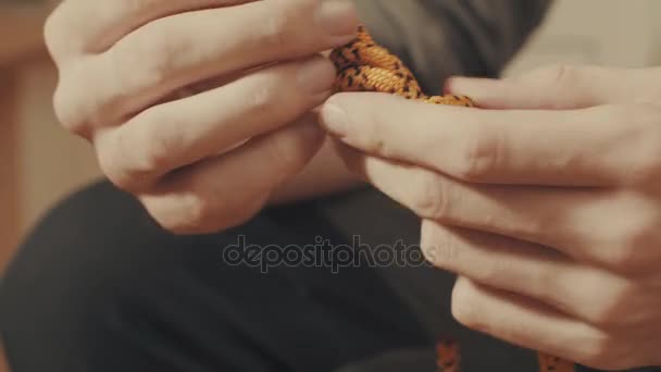 Mans handen koppelverkoop een knoop alpinisme aan een touw — Stockvideo