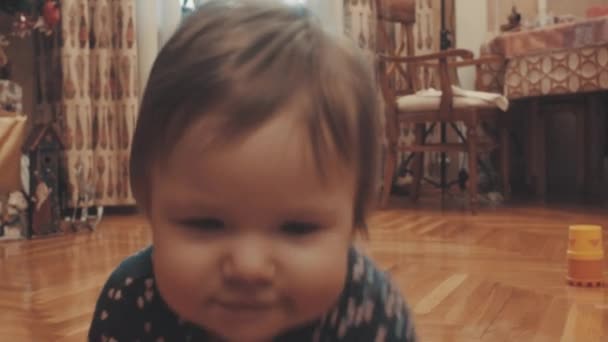 Little baby crawling, then standing up near the cupboard and starting to play — Stock Video