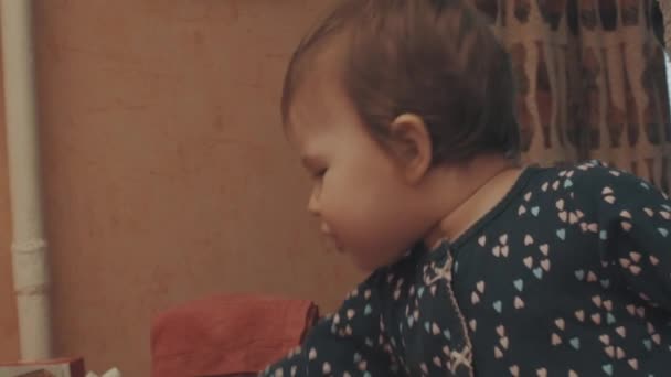Pequeno bebê rastejando sobre a mesa, depois comendo biscoito — Vídeo de Stock