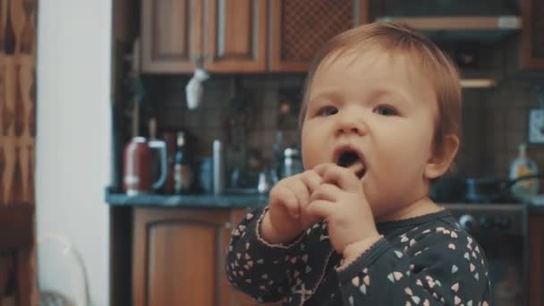 Kleine baby zittend op de tafel en het eten van beschuit — Stockvideo