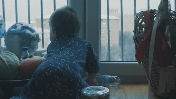Kis baba, játék, és a konyhában, az ablak mellett csúszó — Stock videók