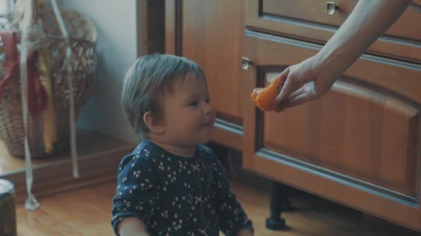 Pequeño bebé preguntando caqui, luego tratar de comerlo — Vídeos de Stock