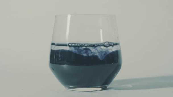 Sombody ajoutant de l'encre dans l'eau, puis de l'encre diffusant 