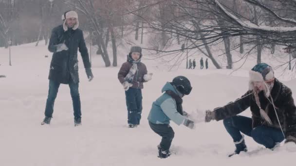 Dwóch chłopców i tam rodzice grający śnieżkami — Wideo stockowe