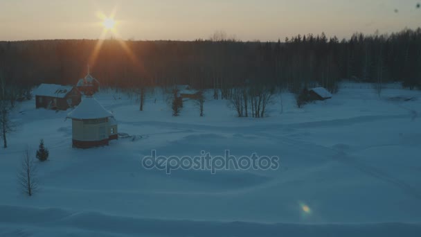 Kleine traditionelle Holzkirche im Wald. Wintersonnenuntergang. — Stockvideo