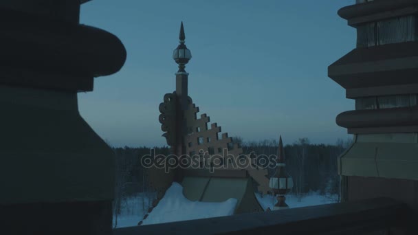 Karla kaplı geleneksel Rus terem bir ormandaki çatısı. Alacakaranlık geliyor. — Stok video