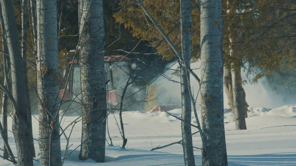 Traktor beseitigt Schnee von der Winterstraße im Wald — Stockfoto