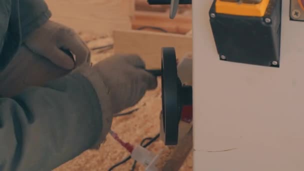 Mans kezében egy működő kesztyű csavaró gép kerék — Stock videók