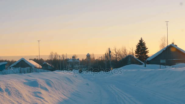 Winter village. Small old church. Sunset — Stock Video