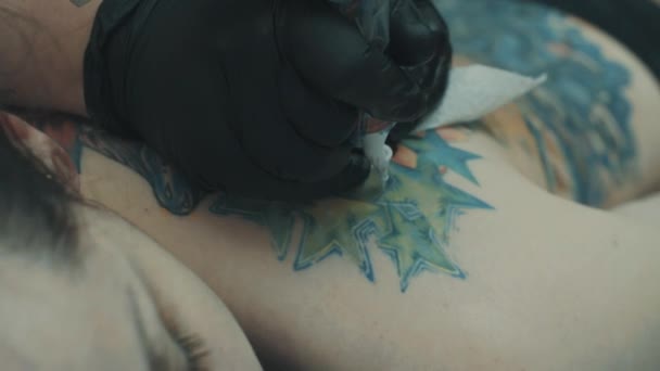 Tattooist making a tattoo on the girls back — Stock Video