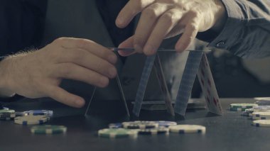 Adamın elleri bir iskambil kartları bir ev inşa