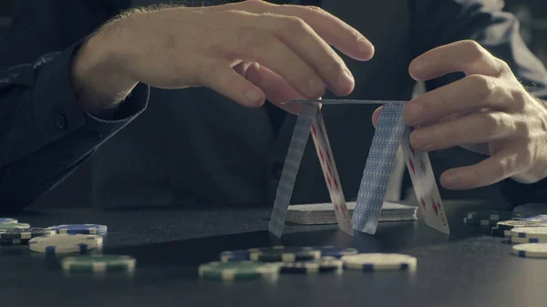 Mãos de homem construindo uma casa de cartas de jogo — Fotografia de Stock