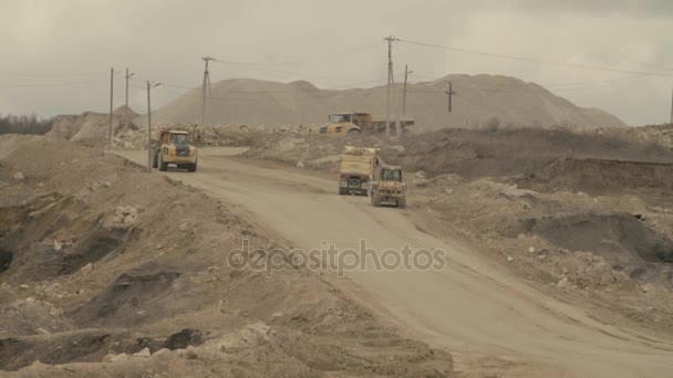 Quatro caminhões e escavadeira em uma estrada em pedreira — Vídeo de Stock