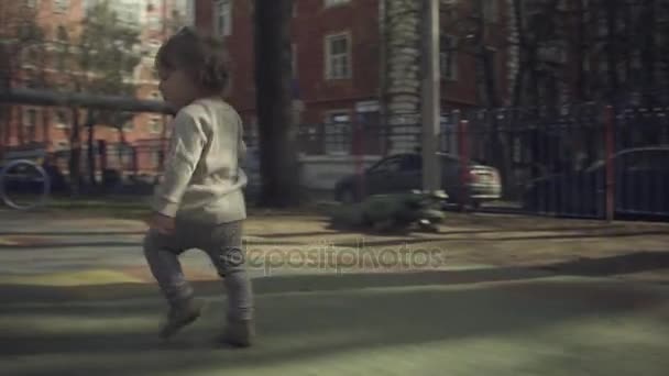 En unge som løper rundt på gårdsplassen – stockvideo