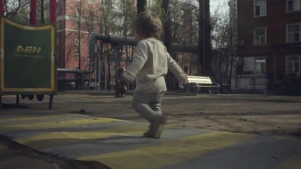 Un niño caminando en el patio — Vídeos de Stock