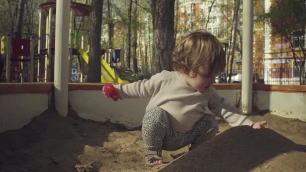 Un niño jugando en una caja de arena — Vídeos de Stock