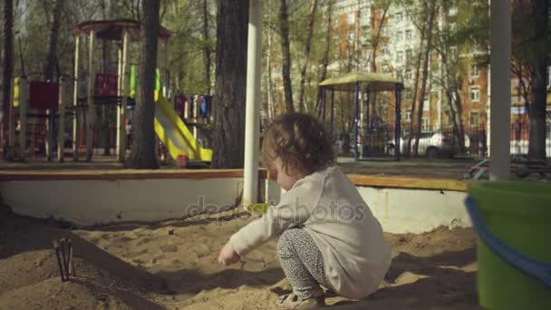 Un gamin jouant dans un bac à sable — Video