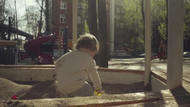 Un niño jugando en una caja de arena — Vídeos de Stock